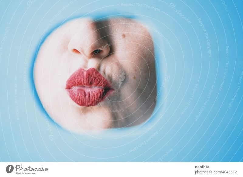 Young woman red lips behind a cover blue circle real covering color sexy sensual attractive contrast detail face kiss shy timidity close quiet censorship