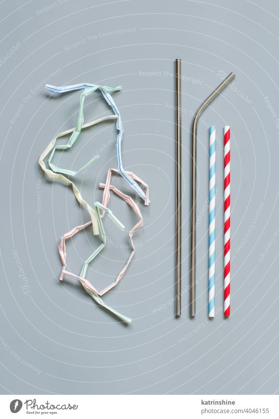 Modern reusable steel and paper drinking straws as alternative replacement for plastic drinking straw disposable grey background top view copy space