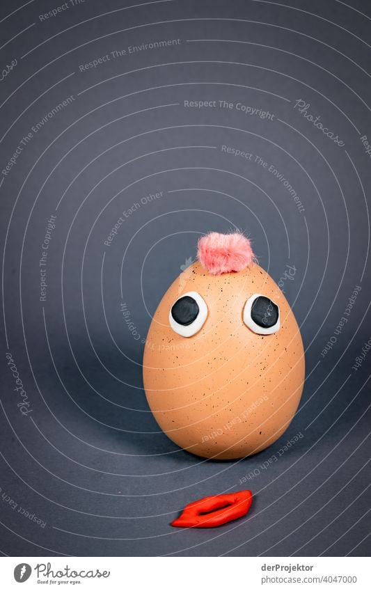 Easter egg with punk hairstyle and eyes and mouth - which lies on the floor - made of plasticine Easter eggs Easter Monday Easter gift Easter wish