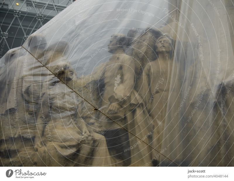encased figures of a monument Work of art Sculpture Tourist Attraction Budapest Monument Historic Transparent Encased in Subdued colour plastic tarpaulin Rope