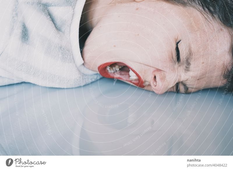 Portrait of a young woman leaning her face against a cold glass table depression blue sad mental health psychology sadness depressive white reflection mirror