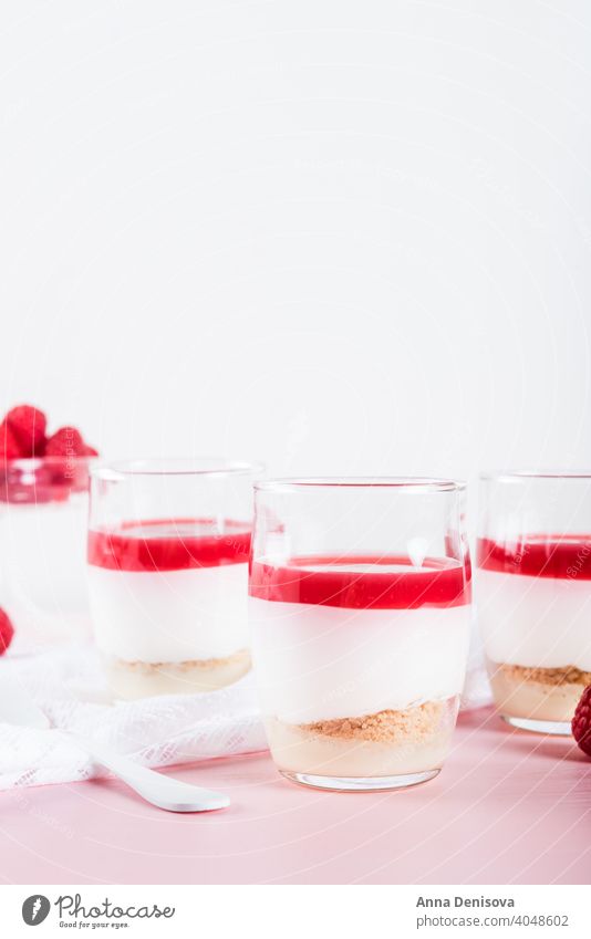 Raspberry dessert from whipped white chocolate mousse and raspbe berry puree jelly jam base almond cookies cheesecake vanilla trifle glass sweet delicious