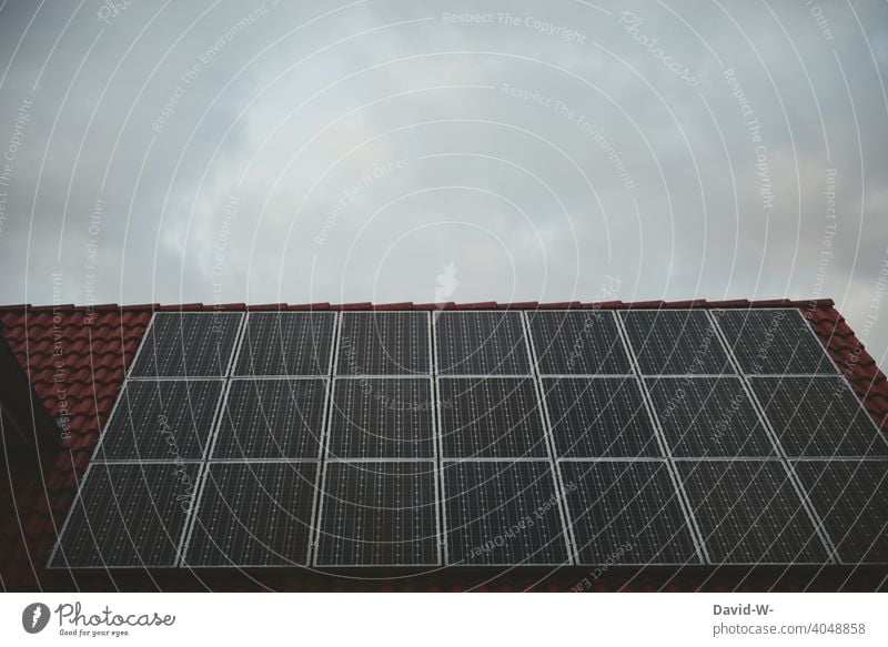 Solar cells on a roof under an overcast sky photovoltaics photovoltaic system Gray somber Bad weather Roof Covered Weather Clouds Solar Energy Renewable energy