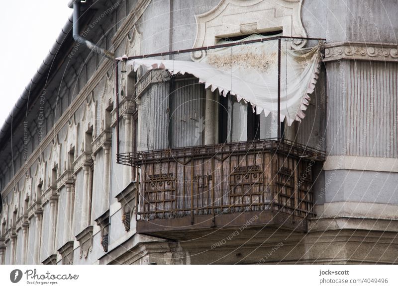 loose awning still hangs over rusty balcony Balcony Weathered Derelict Rust Ravages of time Facade Budapest Change Unkempt Broken Sun blind Rain gutter