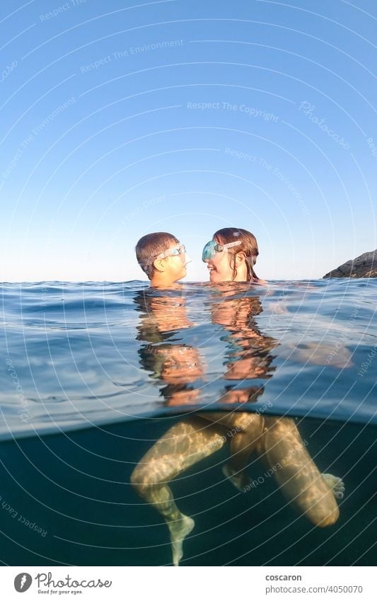 Mother and son snorkeling on a clear water beach blue boy cheerful child childhood diver diving equipment face family female fun half kid leisure little mask