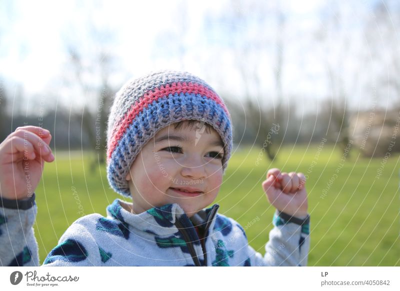 smiling happy small child holding his hands up Looking away Upper body Dependability Exterior shot Multicoloured Help Love Together Safety (feeling of)