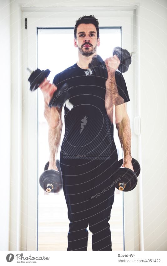 athletic man doing fitness exercises with weights Sports at home Athletic Fitness muscle building workout stay at home Lifestyle Healthy Man Dumbbells