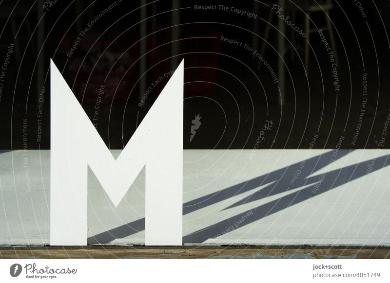 compliant|letter M Capital letter Shop window Sunlight Shadow play Typography Silhouette Neutral Background Individual Pane double Structures and shapes