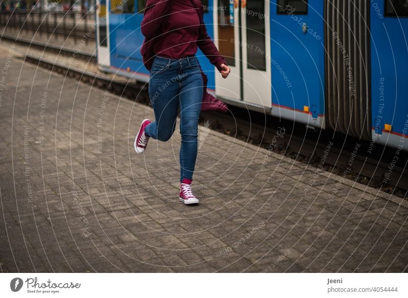 The train has left | A woman runs after a departing tram Woman Running Walking swift hurry Miss out Tram Road traffic Human being jeans Modern Red