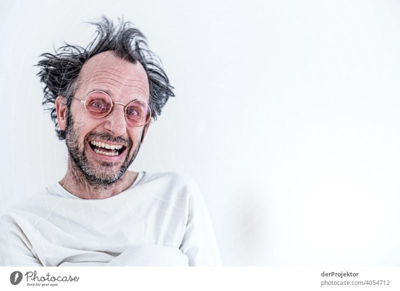 Unshaven and undressed middle-aged man with rose-colored glasses in straitjacket (after three months of homeschooling) forcible jacket Compulsory Homeschooling