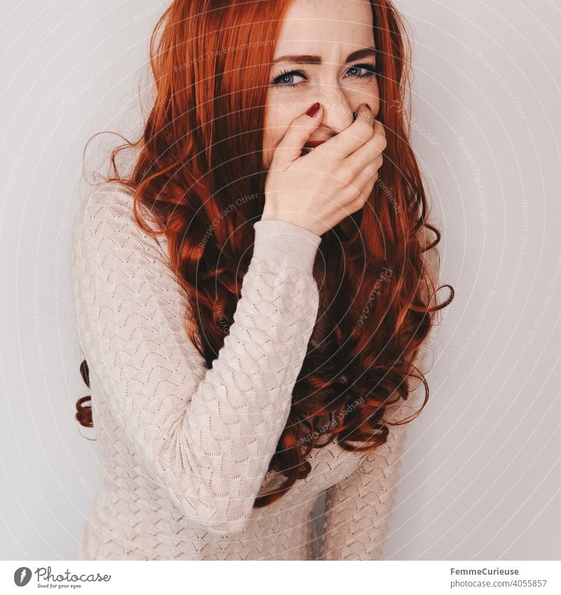 Woman with long red curly hair laughs looking at camera while holding a hand in front of her mouth Hair and hairstyles long hairs red hair Red Curly Nail polish