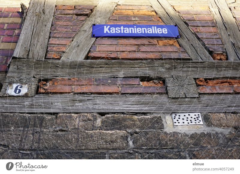 At an old half-timbered house there is a street sign "Kastanienallee" and a sign with the house number 6 / rural living / frog perspective Half-timbered house
