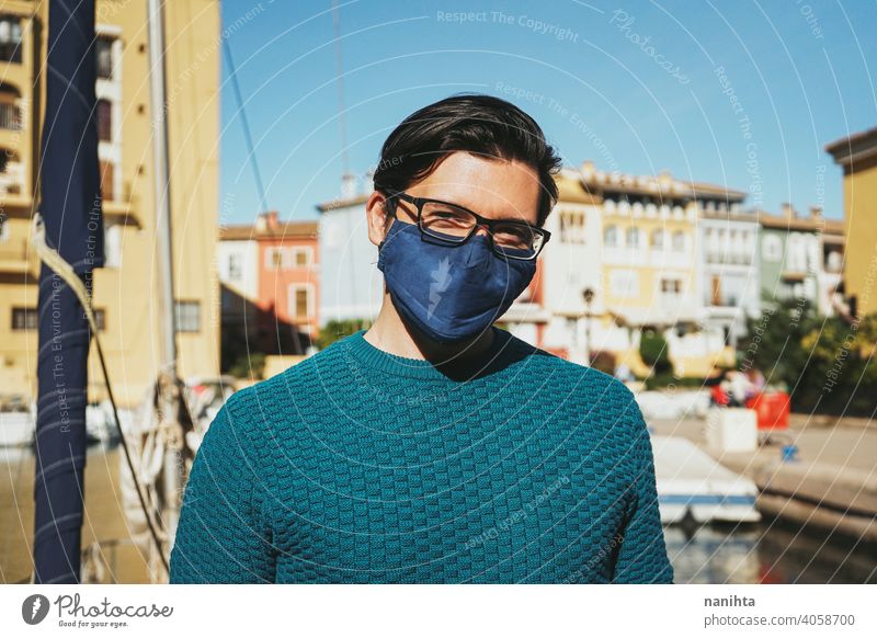 Young man wearing a face mask enjoying a sunny day in Alboraya, Valencia, Spain male holidays summer covid coronavirus flu influenza spain coast water