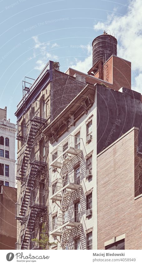 Tenement houses with fire escape in Manhattan, color toning applied, New York City, USA. city building tenement vintage NYC retro symbol old residential home