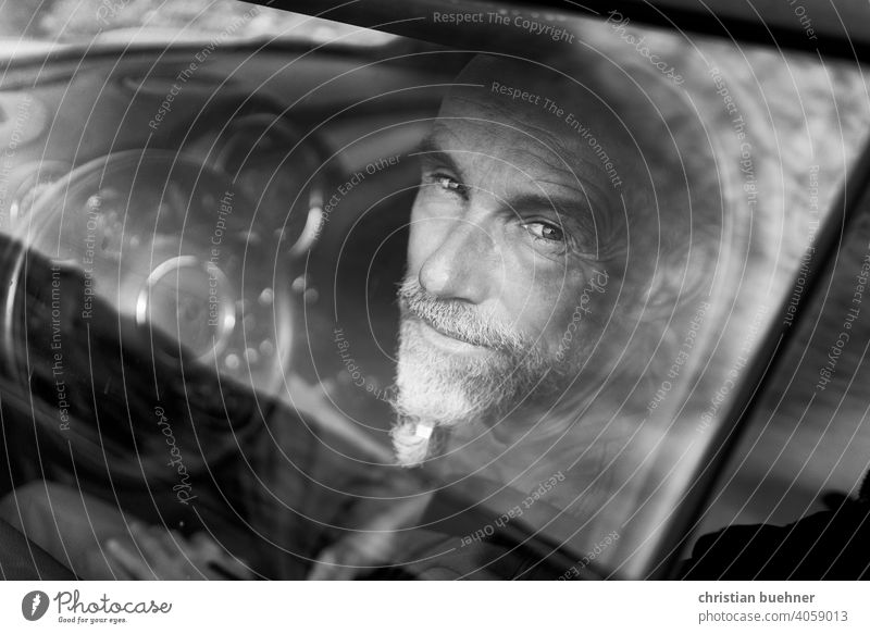 man - sitting in car - looks through window Man portrait Window pane peer critical Steering wheel Interesting Facial hair