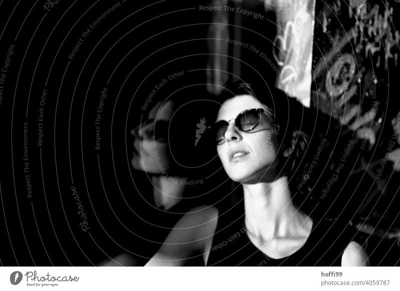 The young woman enjoys the sun Young woman Brunette portrait Looking into the camera pretty Sunglasses 1 Beauty Photography Black & white photo naturally Town