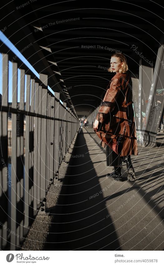 Lara Skeptical Mysterious urban Shadow sunny Bridge pier Metal leather coat Coat hair Blonde Looking Woman Going look around