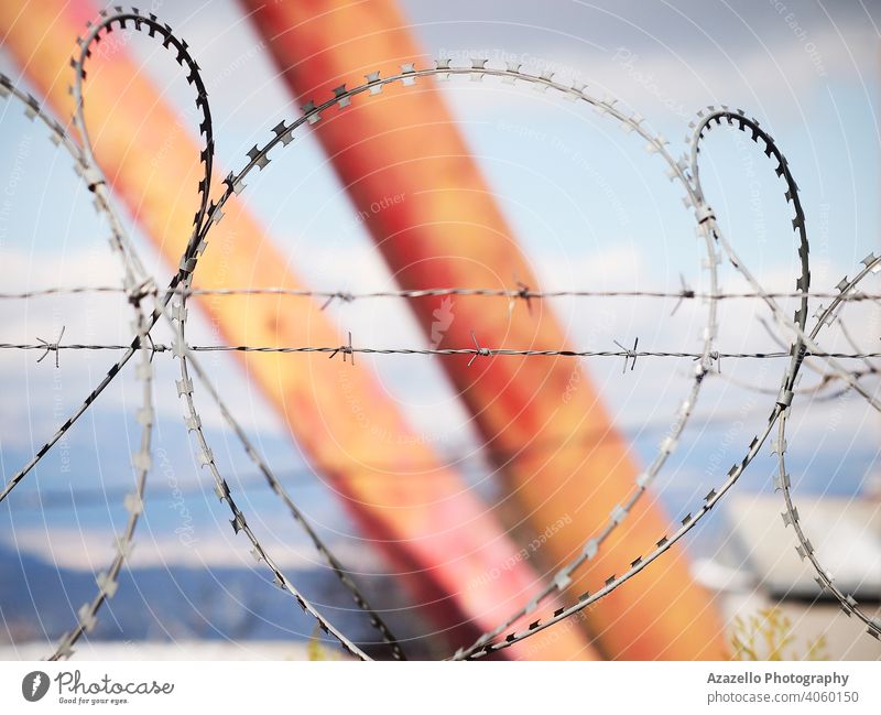 Barbed wire over the fence on a blurred background barbed barbed wire blue blurry bokeh background border boundary concept danger entrance freedom