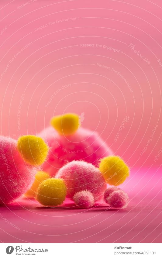Macro shot of rolled up yellow tape measure on pink background Studio shot Studio lighting Pink Yellow Pom pom Band Soft Spring depth Fluffy Depth of field