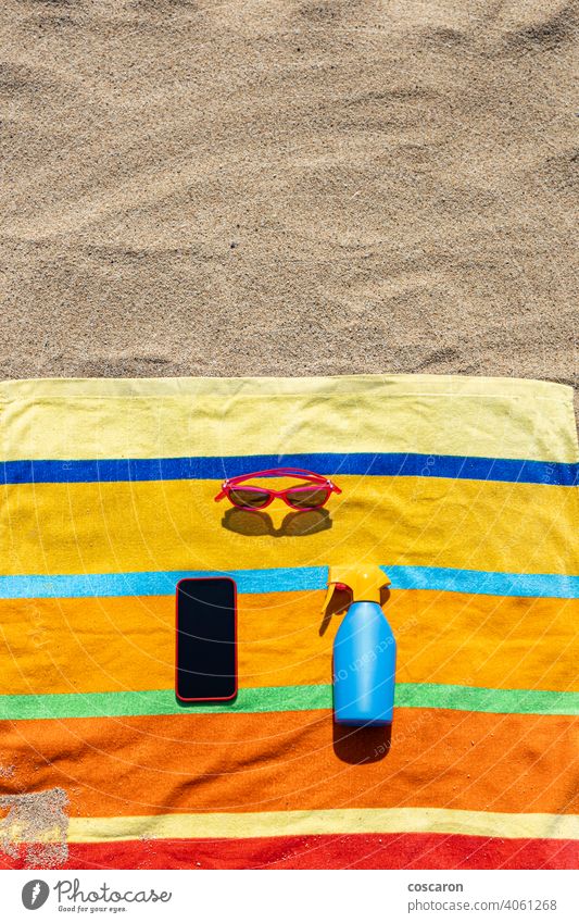 Towel, sunsreen, sunglasses and smart phone on the beach. Summer concept. blue bottle cell colorful communication communications copy copy space cosmetics cream