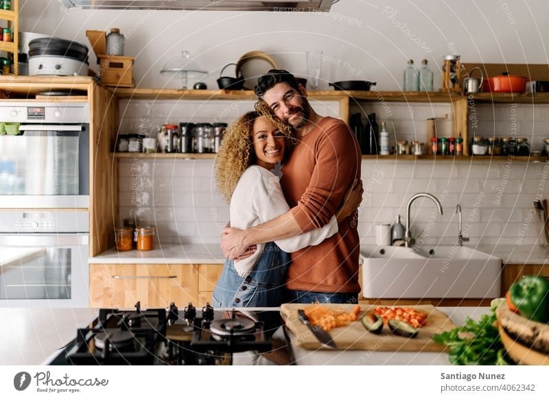 Couple hugging in the kitchen. middle age couple love cooking home cozy caucasian relationship preparing female happy person stove woman beautiful girl smiling