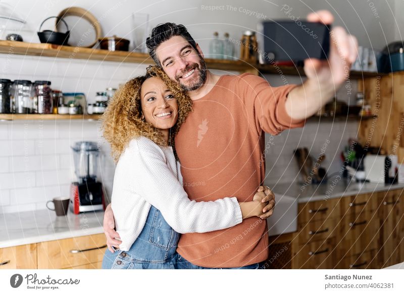 Couple taking a selfie standing in kitchen. middle age couple love cooking home cozy caucasian relationship preparing female happy person stove woman beautiful