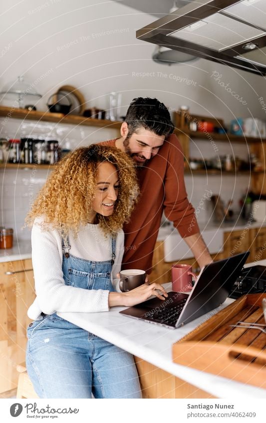Couple looking at laptop in kitchen. middle age couple love cooking home cozy caucasian relationship preparing female happy person stove woman beautiful girl