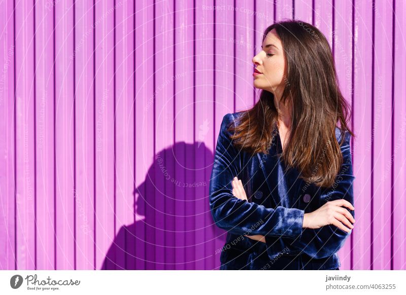 Woman wearing blue suit posing near pink shutter with eyes closed. woman girl person fashion model lifestyle female urban background lady one elegant building