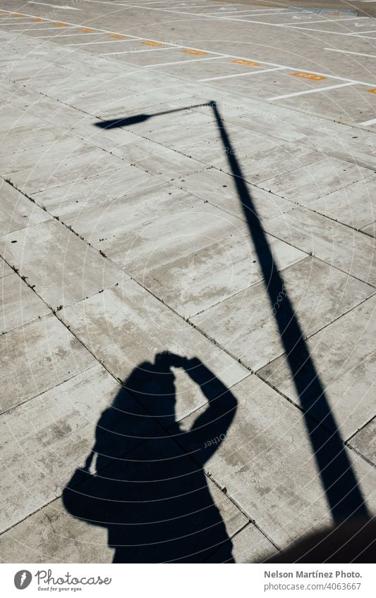 Silhouette of a man taking a picture with another silhouette of a pole black and white photography artistic photographer creative lines figures sunlight floor