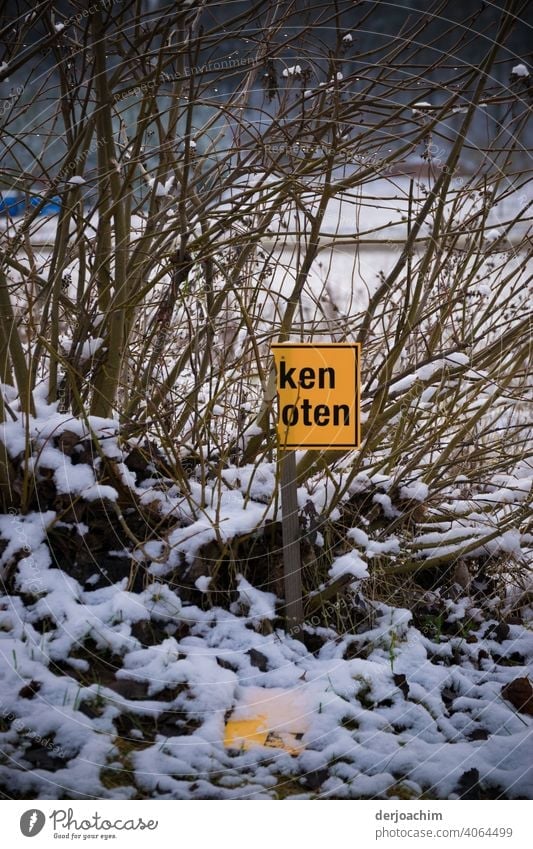 Half torn off sign in a winter landscape . ken oten. The other part lies on the ground ... Signage Exterior shot Letters (alphabet) Close-up Communication