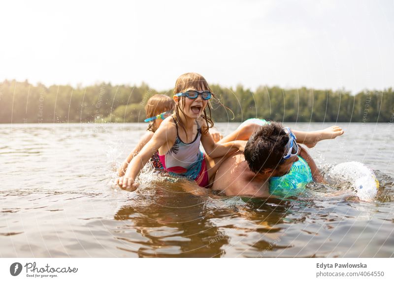 Father and kids having fun in the lake summer vacation travel water laughing day sunny splash drop playing playful father active beach beautiful child childhood
