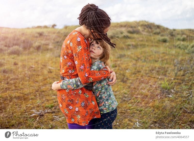 Mother and daughter embracing outdoors mother child family nature hipster dreadlocks love hugging adult beautiful beauty childhood culture dress female field