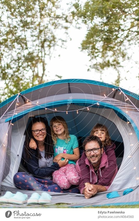 Happy family enjoying camping holiday hiking cycling vacation tent forest children kids happy smiling night evening trek trekking Wilderness wild nature green