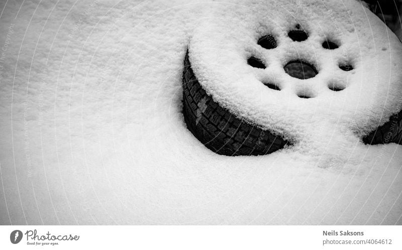 car wheel lies on the side of the road covered with a thick layer of snow Auto automobile automotive background black change circle detail donuts drive