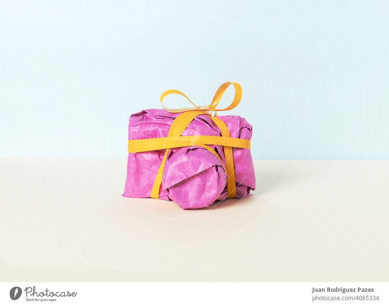 Photo camera wrapped in magenta gift paper and yellow ribbon christmas colorful shopping present photography anniversary birthday presents minimal fun packaging