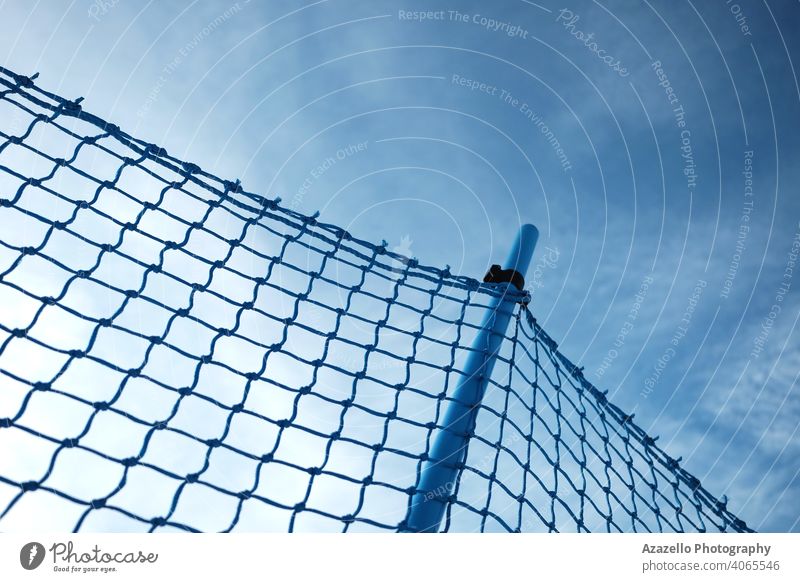 Blue monochrome image of a fence made of a net area atmosphere background barrier border braid clouds construction danger design diagonal division dramatic
