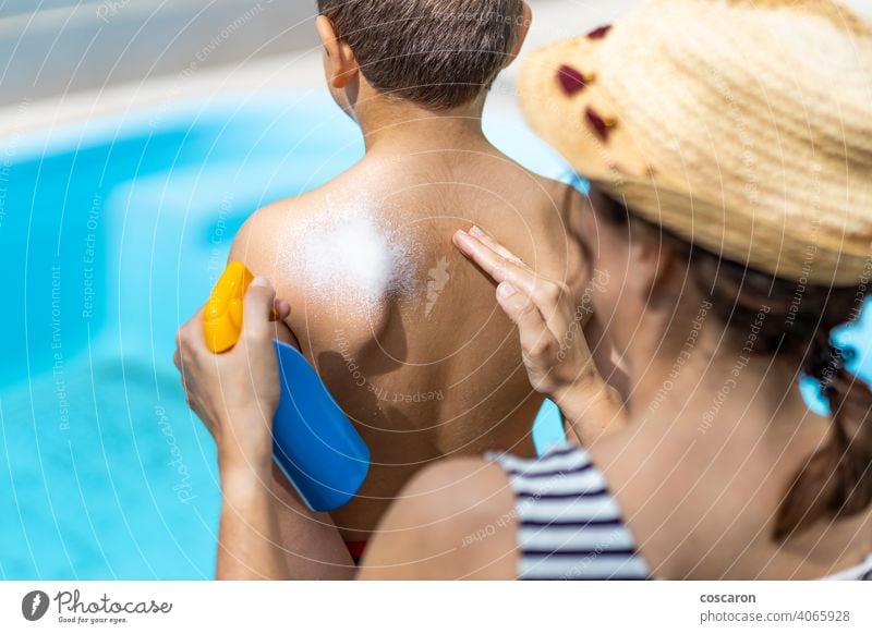 Mother applying sunscreen on her sons back on a summer day beach cancer child childhood cream creme family female hand holiday kid lotion moisturizer mom mother