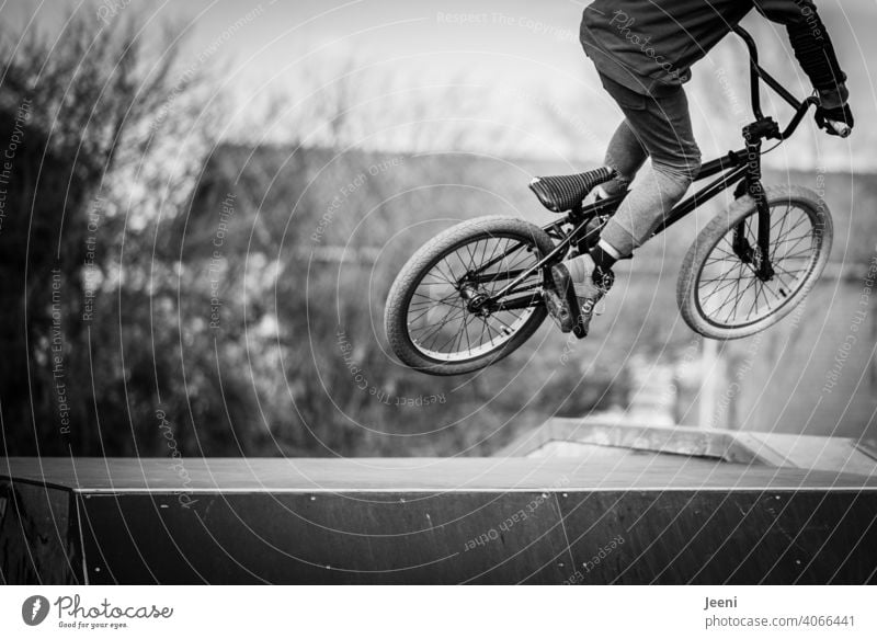 Teen jumps over ramp on BMX bike Bicycle Stunt Ramp Jump Tall across youthful Sports Movement Extreme sports Trick Action Lifestyle Style Cycling Freestyle