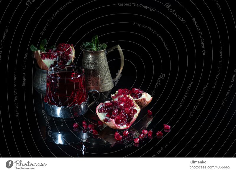 Pomegranate juice in a glass and pomegranate slices on a dark background. Vitamin drink. Still life. grains fresh vitamins benefit food red fruity refresh