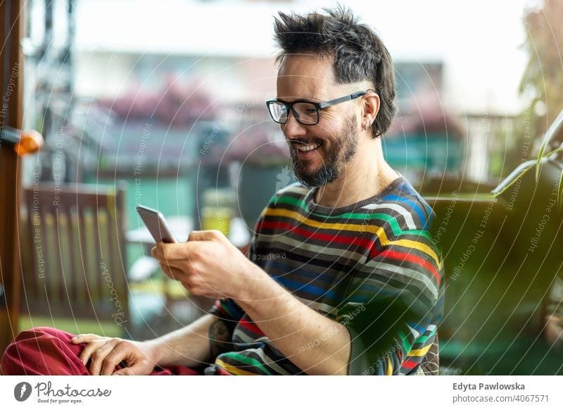 Happy man using a mobile phone at home work freelancer blogger guy call texting online caucasian electronic network digital customer retail shop touch finger