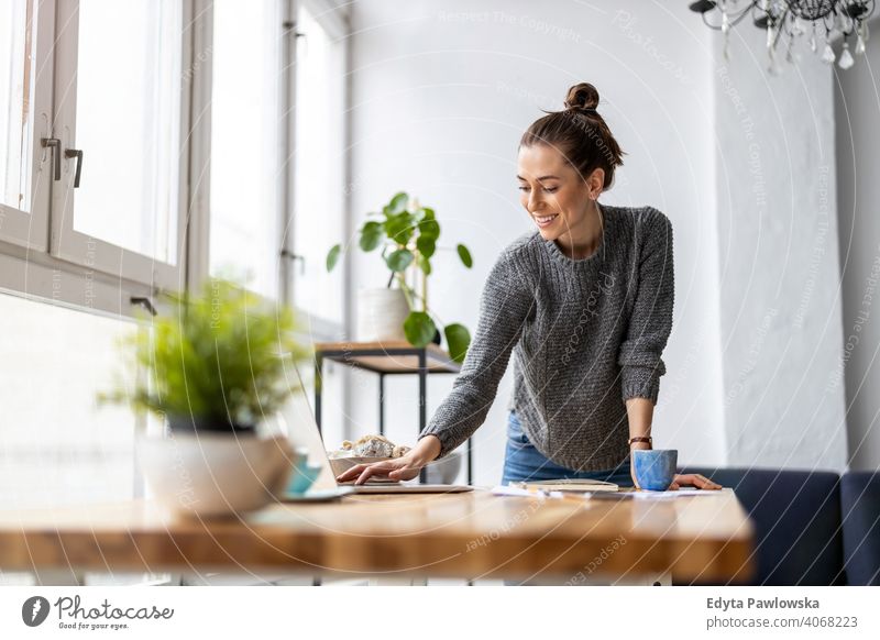 Creative young woman working on laptop in her studio millennials student hipster indoors loft window natural girl adult one attractive successful people