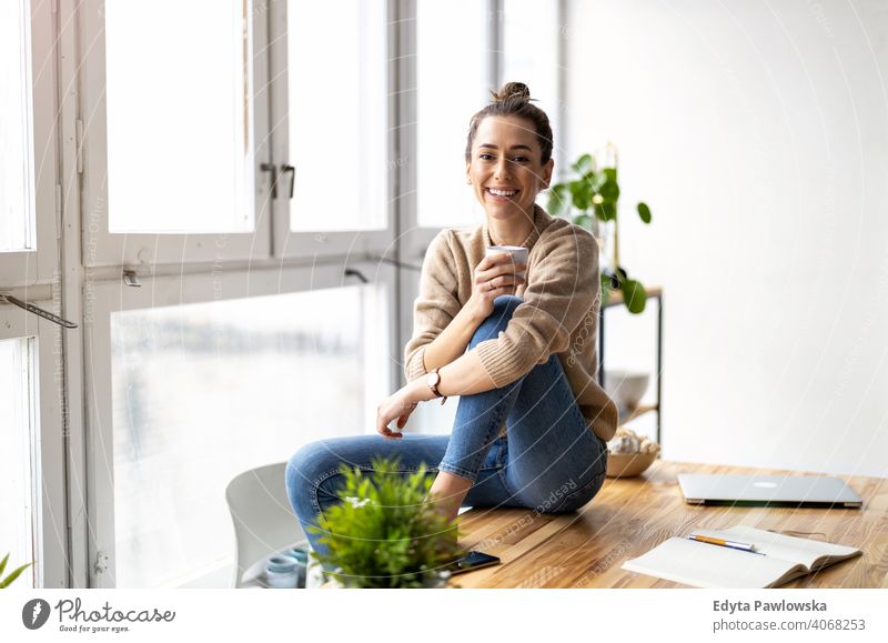Portrait of a smiling creative woman in a modern loft space millennials student hipster indoors window natural girl adult one attractive successful people