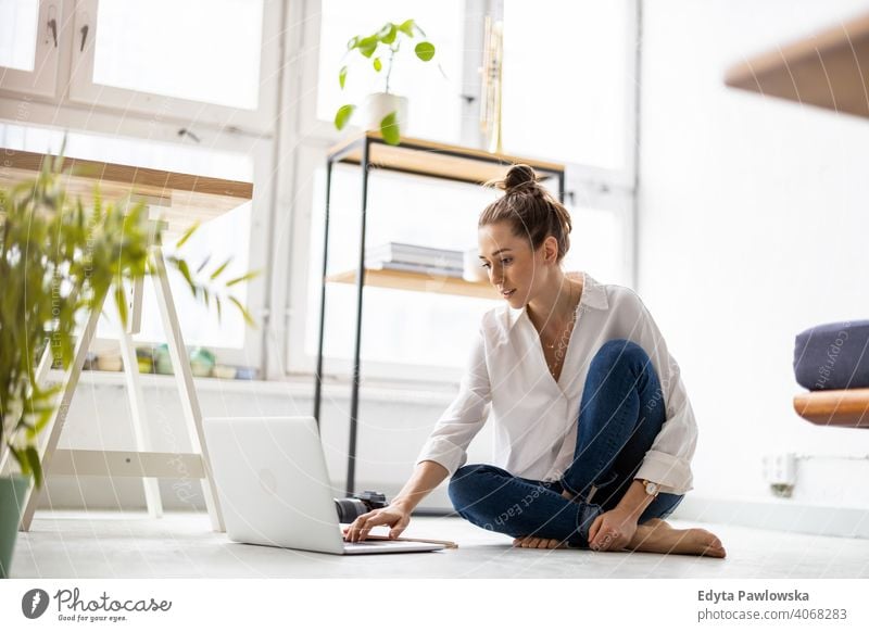 Creative young woman working on laptop in her studio millennials student hipster indoors loft window natural girl adult one attractive successful people