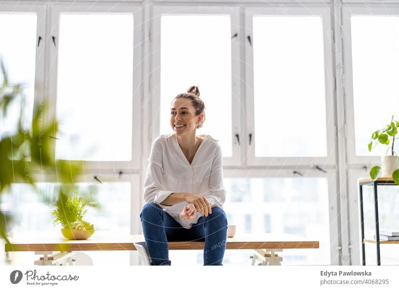 Portrait of a smiling creative woman in a modern loft space millennials student hipster indoors window natural girl adult one attractive successful people