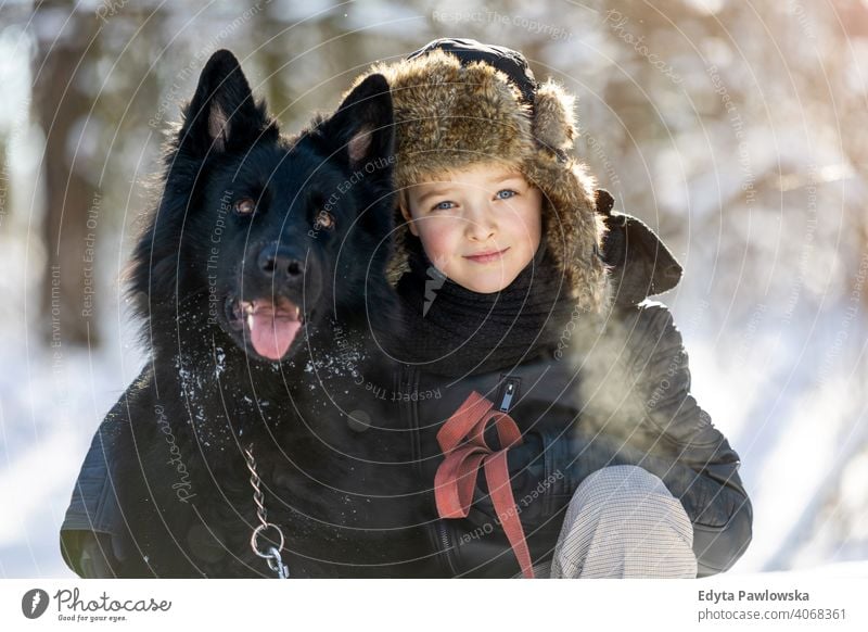 Little boy enjoying winter with his dog black russian activity active adventure day male companion care outdoors forest beauty frost nature tree portrait