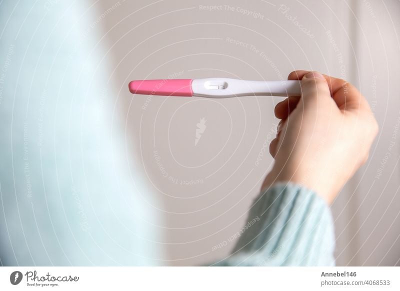 Young woman holding negative pregnancy test,home pregnancy test showing negative result close up pregnant medical fertility female baby health young positive