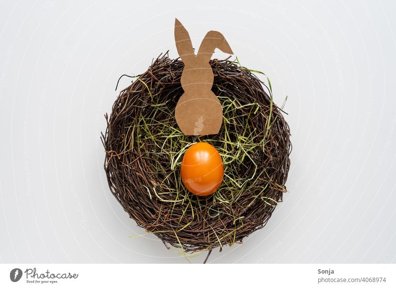 A paper Easter bunny and an Easter egg in a nest Nest Easter Bunny Paper Self-made white background plan Colour photo Easter egg nest Tradition Studio shot Egg