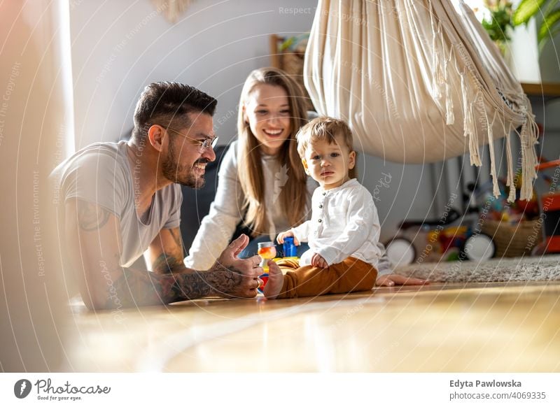 Young family having fun together at home father son child house girl adorable toddler parenting room daughter apartment handsome playing playful infant small