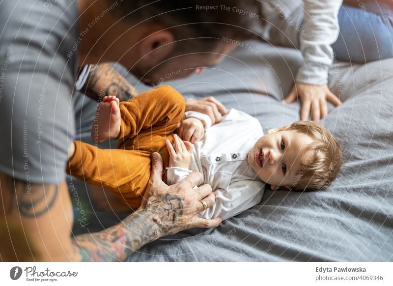 Father tickling his little son in bed single parent single dad fathers day fatherhood stay at home dad paternity leave modern manhood family child house girl