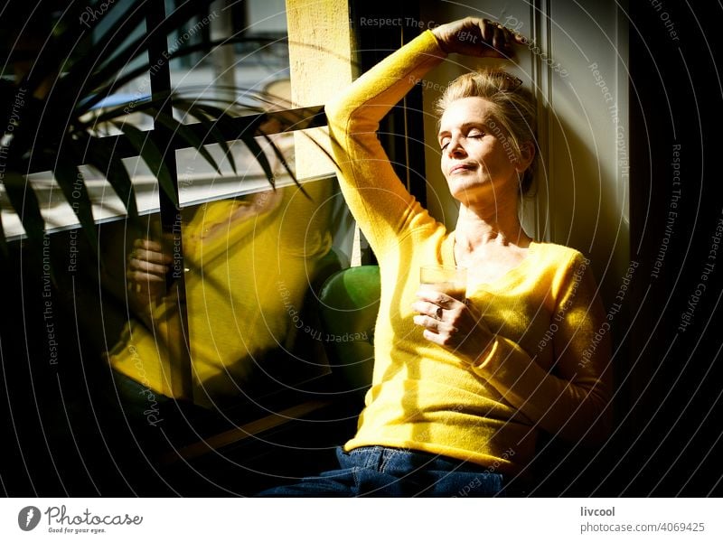 woman taking a break in a cafe blonde people shadow flowers yellow coffee drink drinking interior local coffee shop cafeteria scene light restaurant city